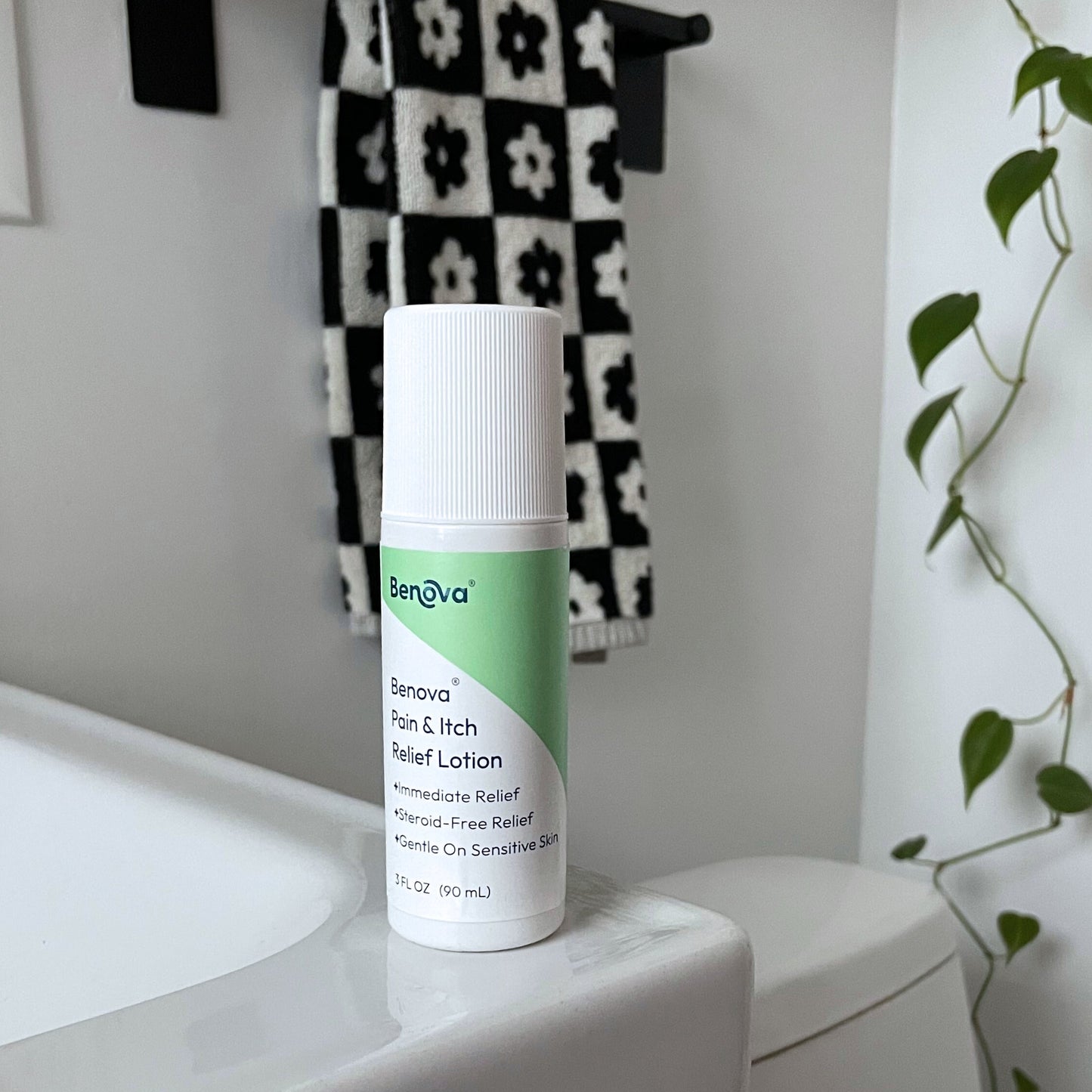 Beneva lotion bottle on a bathroom counter with a checkered towel in the background